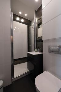a bathroom with a toilet and a sink and a mirror at Kwiatowa Warsaw Apartment in Warsaw