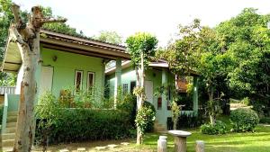 una casa verde con un árbol delante en Rainbow House Pai, en Pai