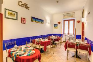 a restaurant with tables and chairs with red tablecloths at Hotel Gea Di Vulcano in Rome