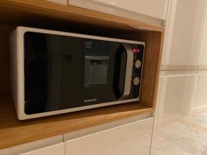 a microwave oven sitting in a wooden cabinet at Modern and New Family flat in Beylikdüzü in Beylikduzu