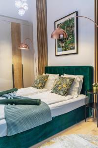 a bedroom with a green bed with two pillows at BRAND NEW LOFT LUXURY PENTHOUSE WITH JACUZZI #Centropolitan in Budapest