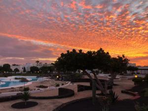 einen Sonnenuntergang über einem Pool in einem Resort in der Unterkunft Casa Yuma in Costa Teguise