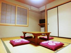 a room with a table and two red mats at Oyado Uemasa in Nozawa Onsen