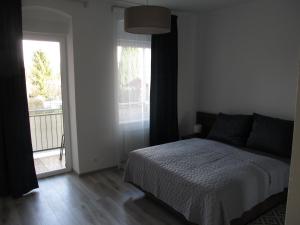 um quarto com uma cama e uma porta para uma varanda em Appartment Ipsum em Löbau