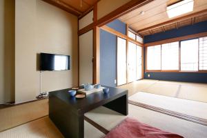 a living room with a table and a flat screen tv at Tamanoi in Tokyo