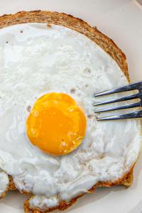 a fried egg on a plate with a fork at De Roos Leeuwarden in Leeuwarden