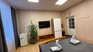 a room with a tv and a bed with towels at Central Hostel Jelgava in Jelgava
