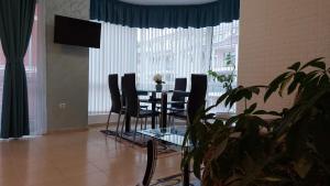 a dining room with a table and chairs and a television at Sunny houm in Nesebar