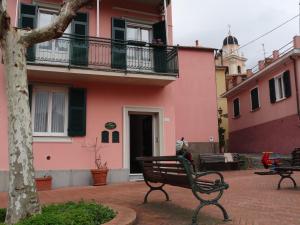 a park bench in front of a pink building at La Piazzetta in Sestri Levante
