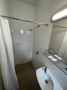 bagno bianco con lavandino e specchio di Hi-Way Motel Grafton - Contactless a Grafton