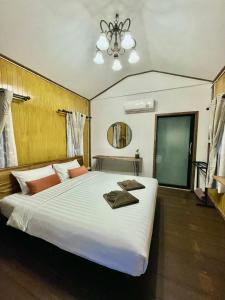 ein Schlafzimmer mit einem großen weißen Bett mit Handtüchern darauf in der Unterkunft Rimwang The River Life in Sai Yok