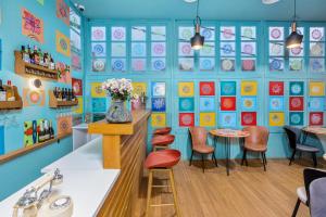 a restaurant with colorful walls and tables and chairs at Blue Balcony Hotel in Tbilisi City