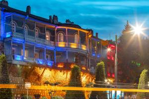 budynek z niebieskimi światłami na ulicy w obiekcie Blue Balcony Hotel w mieście Tbilisi City