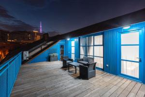 a balcony of a blue building with a table and chairs at Blue Balcony Hotel in Tbilisi City