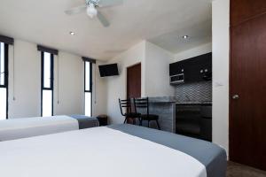 a hotel room with two beds and a kitchen at Capital O Hotel Joyma Suites, San Luis in San Luis Potosí