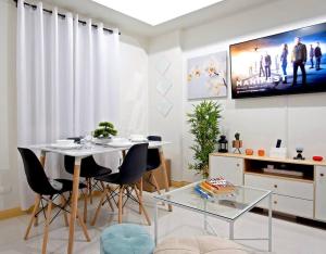 uma sala de estar com uma mesa e cadeiras e uma televisão em 2BR Condo Unit with Washer, INET, Desk Space, ground floor em Davao