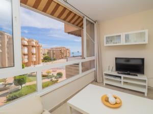 un soggiorno con una grande finestra e una TV di Cubo's Apartamento Costa del Oro a Torrox
