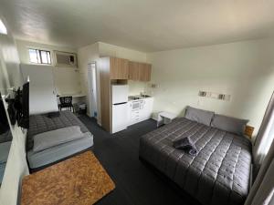a small bedroom with two beds and a kitchen at Hi-Way Motel Grafton - Contactless in Grafton