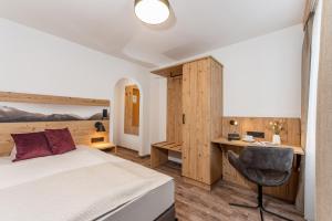 1 dormitorio con cama y escritorio en Hotel Hierzegger, en Tauplitzalm