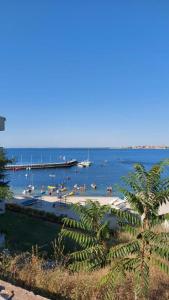 a beach with a pier and boats in the water at Sunny houm in Nesebar
