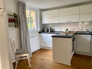 a kitchen with white cabinets and a chair in it at Gemütliches Ferienhaus im Extertal/ Lippe in Extertal
