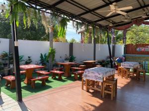 un patio avec des tables en bois, des bancs et des plantes dans l'établissement DD Grand Hotel, à Ban Na Ta Kai