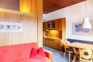 ein Wohnzimmer mit einem roten Sofa und einem Tisch in der Unterkunft Haus Excelsior Top 13 in Seefeld in Tirol