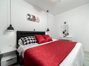a bedroom with a large bed with a red blanket at Apartment Dionis Domus in Vela Luka