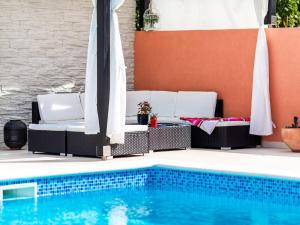 a pool with chairs and umbrellas next to a swimming pool at Apartment Dionis Domus in Vela Luka +48 photos