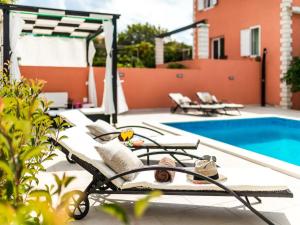 a patio with a pool and lounge chairs next to at Apartment Dionis Domus in Vela Luka