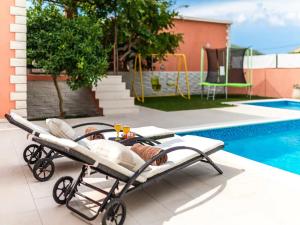 un cochecito de bebé en un patio junto a una piscina en Apartment Dionis Domus, en Vela Luka