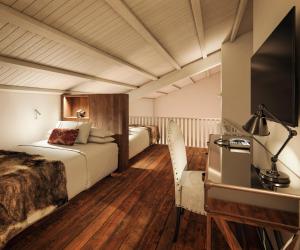 a hotel room with two beds and a television at Hotel Maribel in Sierra Nevada