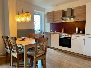 a kitchen with a table and chairs in a kitchen at Ferienwohnung Clyde in Sankt Andreasberg