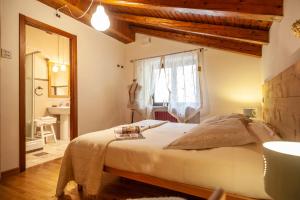 a bedroom with a large bed and a bathroom at Maison Le Champ B&B Questa casa non è un albergo in La Salle