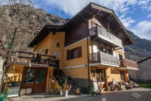 una grande casa gialla con balcone di Maison Le Champ B&B Questa casa non è un albergo a La Salle