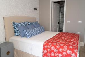 ein Bett mit roten und blauen Kissen darauf in der Unterkunft Limani Luxury Apartments Beachfront in Sarandë