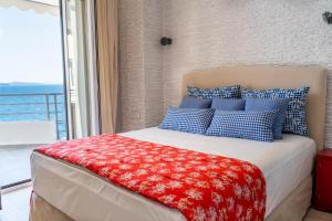Schlafzimmer mit einem Bett mit blauen und weißen Kissen in der Unterkunft Limani Luxury Apartments Beachfront in Sarandë