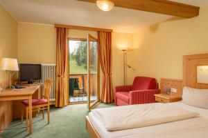 a hotel room with a bed and a desk and a chair at Hotel Hierzegger in Tauplitzalm