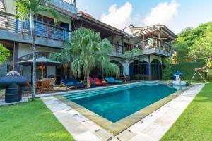 an exterior view of a house with a swimming pool at NicoNico Mansion in Seminyak