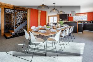 Chalet Argali - OVO Network في لو غراند بورناند: غرفة طعام مع طاولة طويلة وكراسي بيضاء