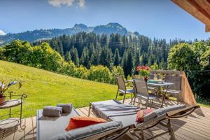 una terrazza con tavolo, sedie e vista sulle montagne di Chalet Argali - OVO Network a Le Grand-Bornand