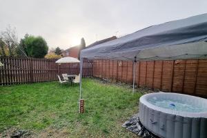 a hot tub in a yard with a tent at *5SM* Setup for your most relaxed & amazing stay + Free Parking + Free Fast WiFi * in Morley