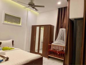 um quarto com uma cama e um berço com uma ventoinha de tecto em Siemreap City Residence em Siem Reap