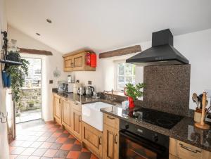 uma cozinha com armários de madeira e um forno com placa de fogão em Tir Eironwy em Pwllheli