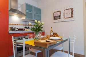 a kitchen with a table with a vase of flowers at Pascoli Home a Cattolica Centro Mare by Yohome in Cattolica