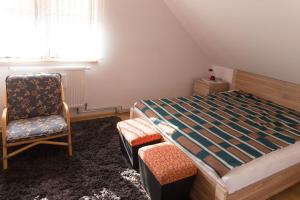 a bedroom with a bed and a chair and a window at Ranczo Marzenia in Długie