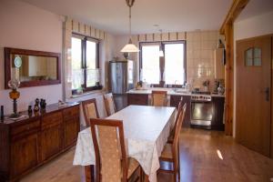 eine Küche mit einem Tisch und Stühlen im Zimmer in der Unterkunft Ranczo Marzenia in Długie