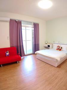 ein Schlafzimmer mit einem Bett und einem roten Sofa in der Unterkunft Home is Love house Homestay in Chaozhou