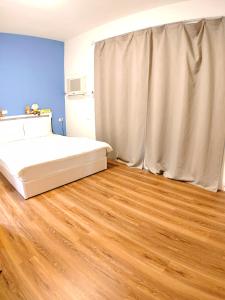 潮州鎮的住宿－家是愛之窩民宿 ，一间卧室配有一张床,铺有木地板