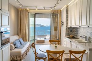 a kitchen and living room with a table and a view of the ocean at Limani Luxury Apartments Beachfront in Sarandë